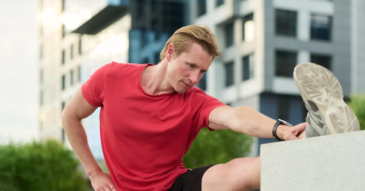 Persona haciendo ejercicios dinámicos de calentamiento al aire libre antes de correr